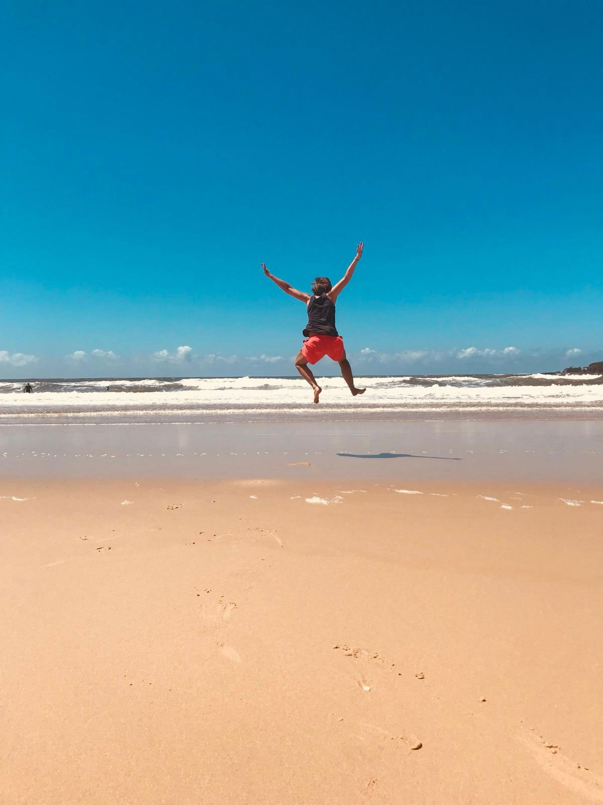 Nicole Riepel hüpft freudig am Strand in Australien